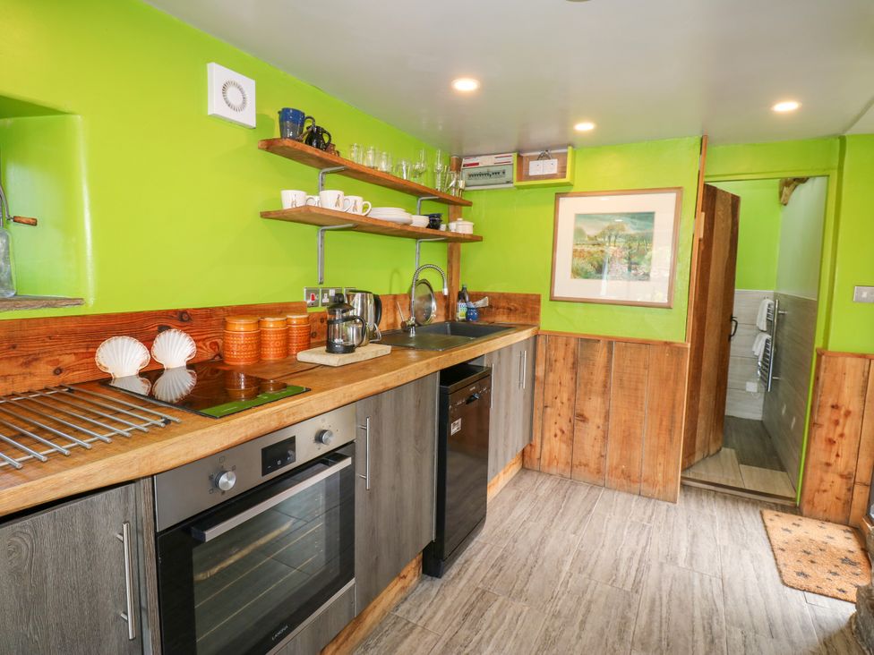 A kitchen with a sink, oven, and shelves at The Brew House in Penrith