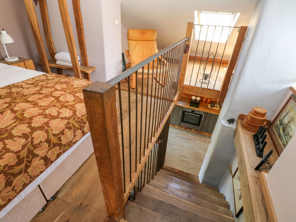 A loft with stairs leading to a kitchen at The Brew House in Penrith