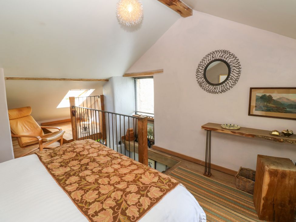 A bedroom with a bed, chair, and window at The Brew House in Penrith