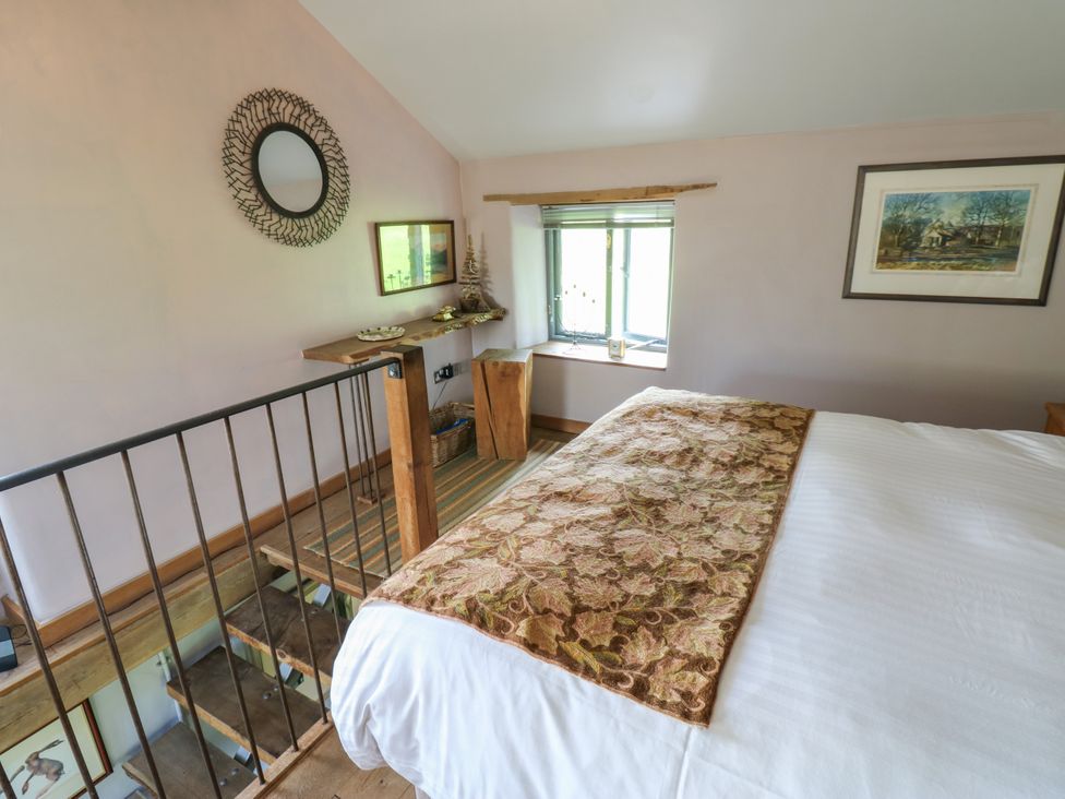 A bedroom with a bed, mirror, and window at The Brew House in Penrith