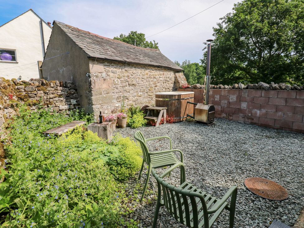 A garden with a hot tub and chairs at The Brew House in Penrith