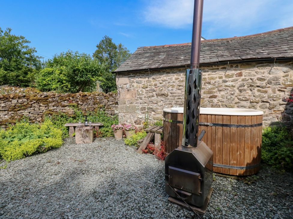 An outdoor area with a wood-fired hot tub and a wood stove at The Brew House in Penrith