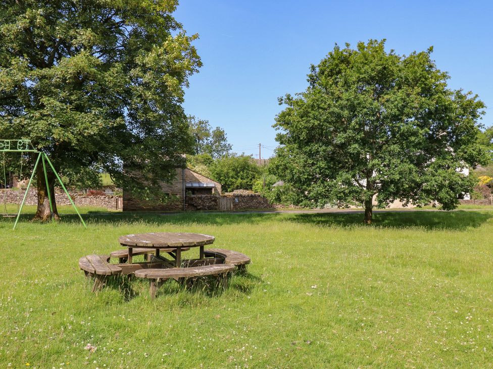 A picnic table and swing set in a garden at The Brew House Penrith