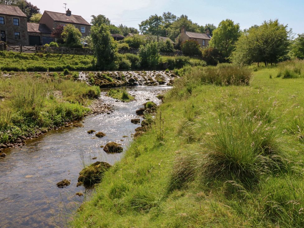 A stream with rocks and grass near buildings at The Brew House in Penrith