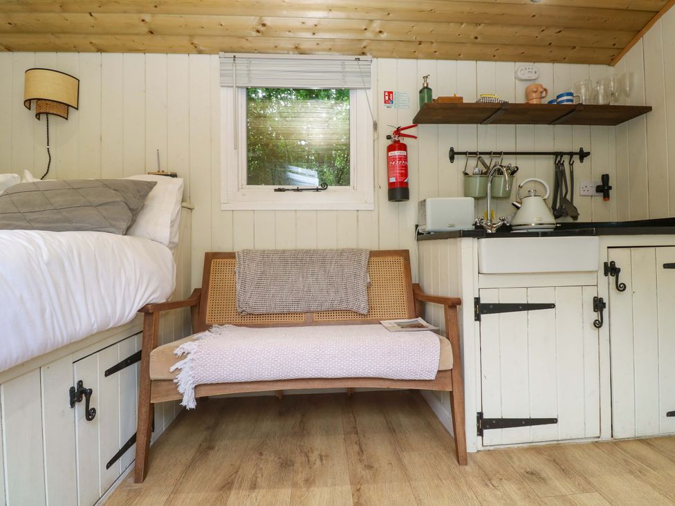 A living room with a bed and sink at Shepherds Hut in Truro