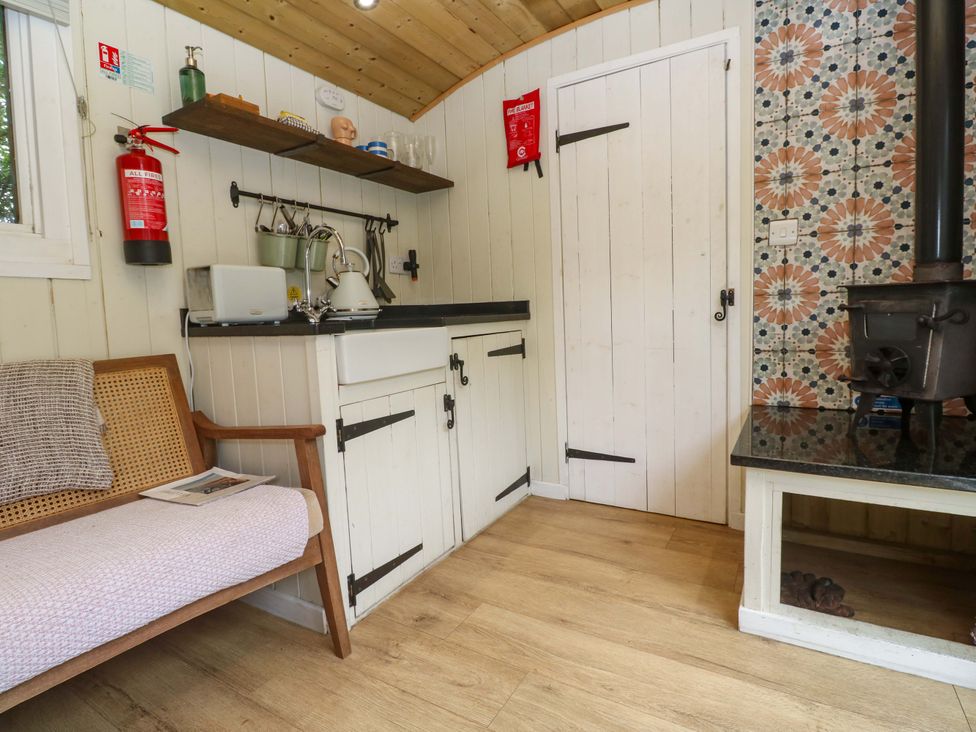 A kitchen with a sink and wood stove at Shepherds Hut in Truro