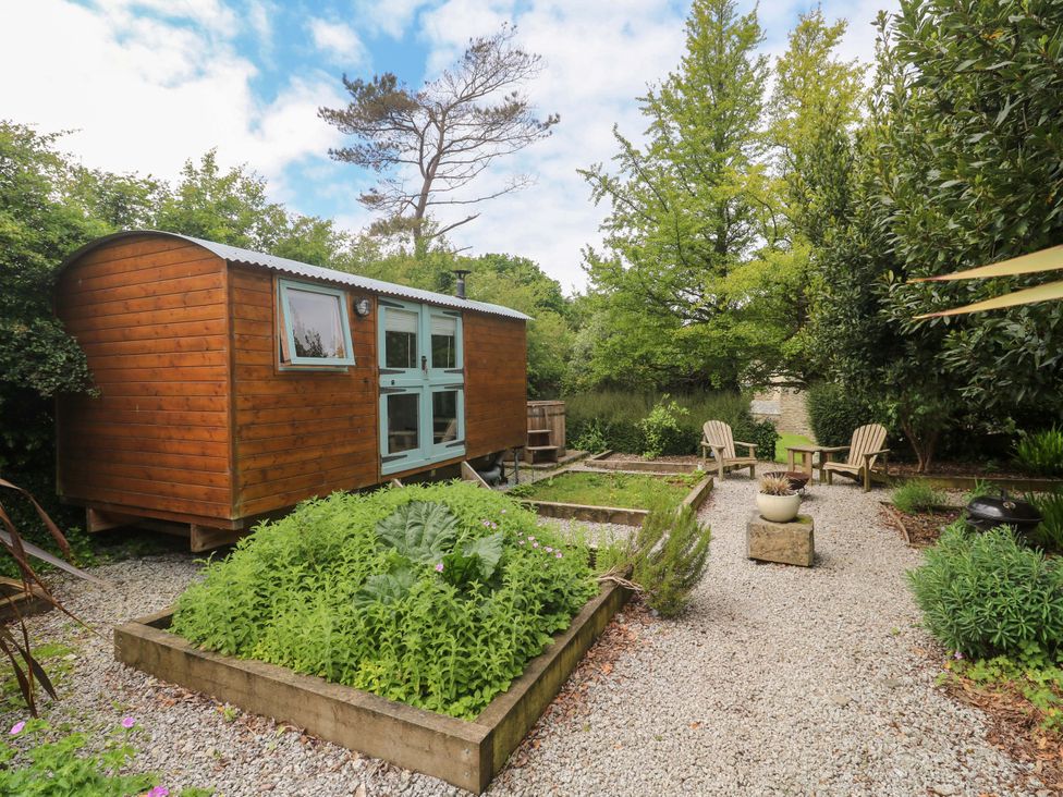 A wooden cabin and garden area at Shepherds Hut in Truro