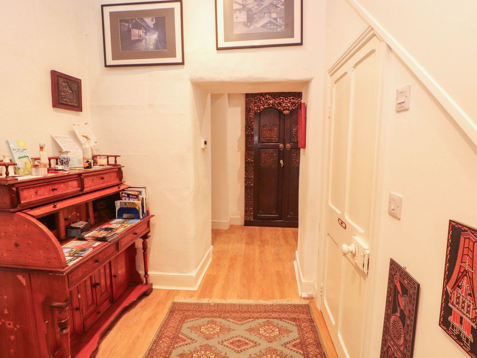 A hallway with a wooden cabinet and door at The School House in Penrith