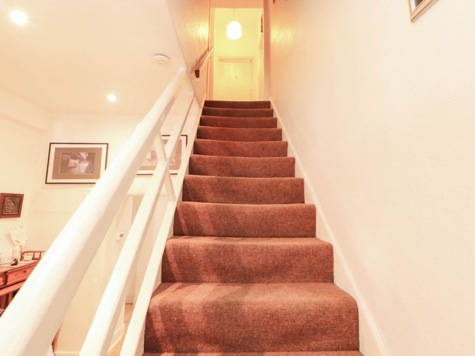A staircase with carpet and handrail at The School House in Penrith