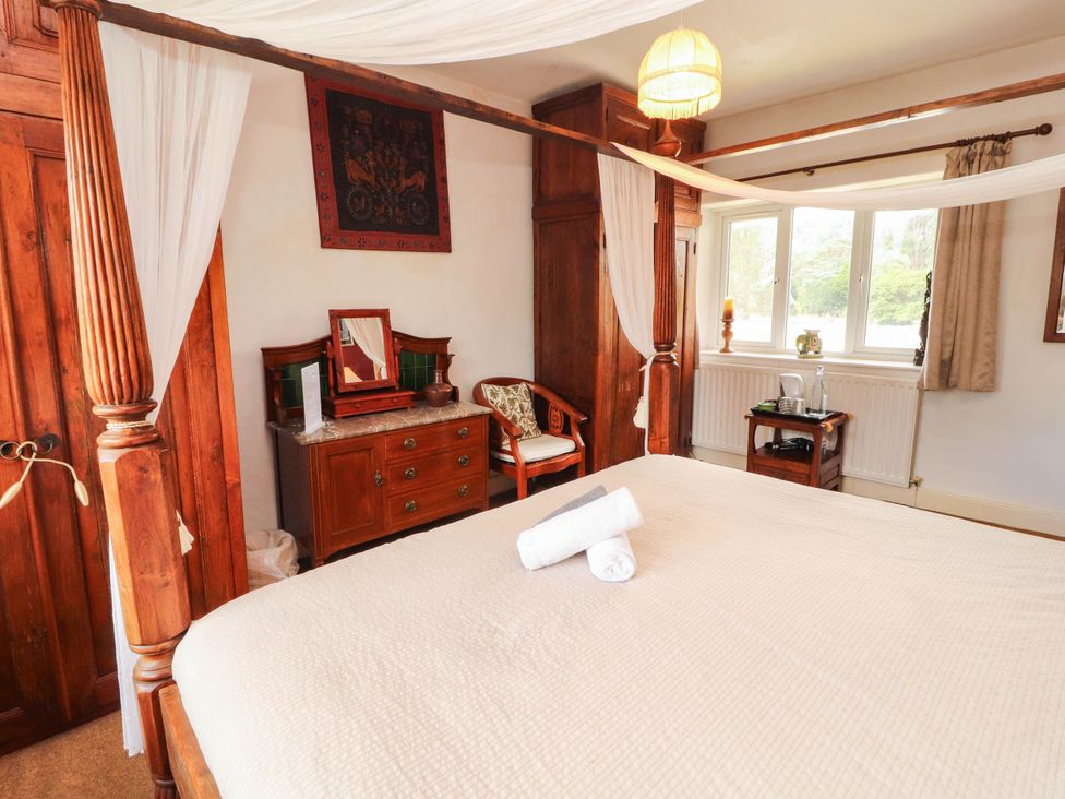 A bedroom with a bed and wooden furniture at The School House in Penrith