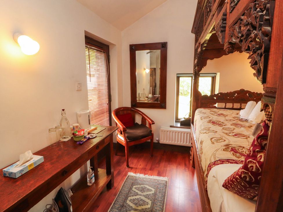 A bedroom with a carved bed and wooden furniture at The School House in Penrith