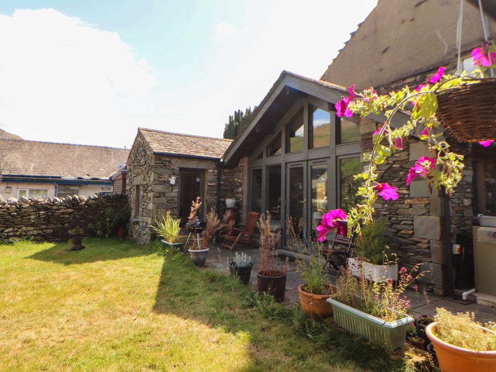 A garden with flower pots and a stone wall at The School House in Penrith