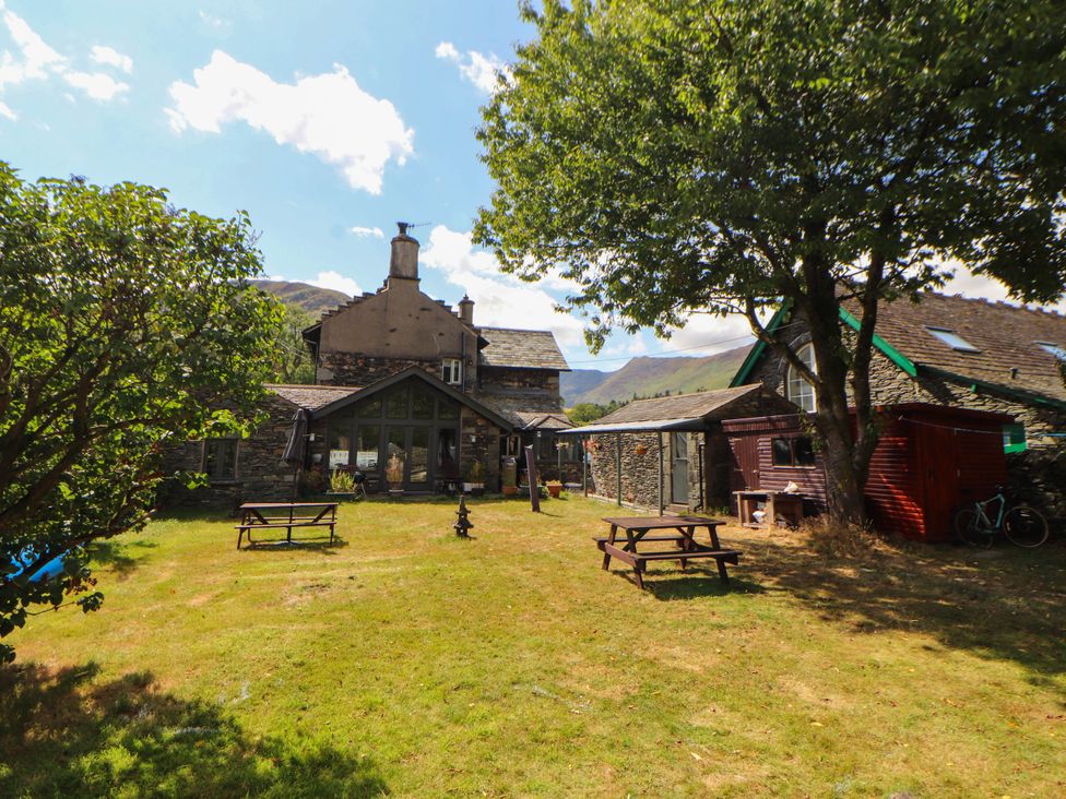 An outdoor area with a house and benches at The School House in Penrith