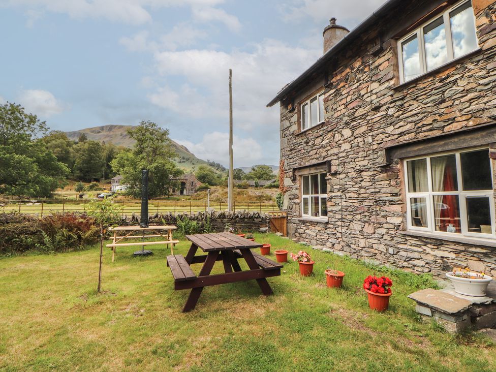 An outdoor area with a picnic table and flower pots at The School House near Glenridding