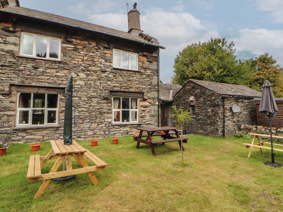A garden with a stone house and picnic table at The School House in Patterdale near Glenridding