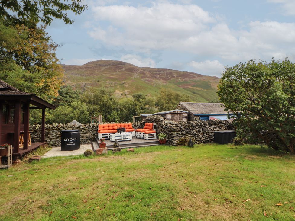 A garden with outdoor furniture and a wooden structure at The School House Patterdale near Glenridding