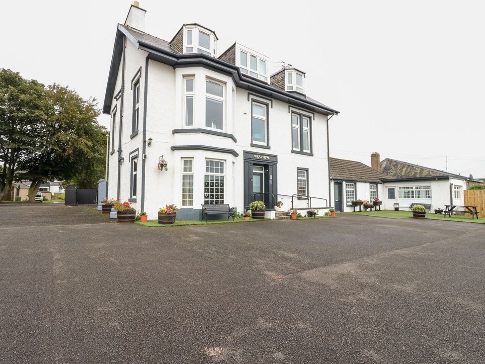 An exterior view of a building with a parking area at Seaview Wellness Retreat in Carnoustie