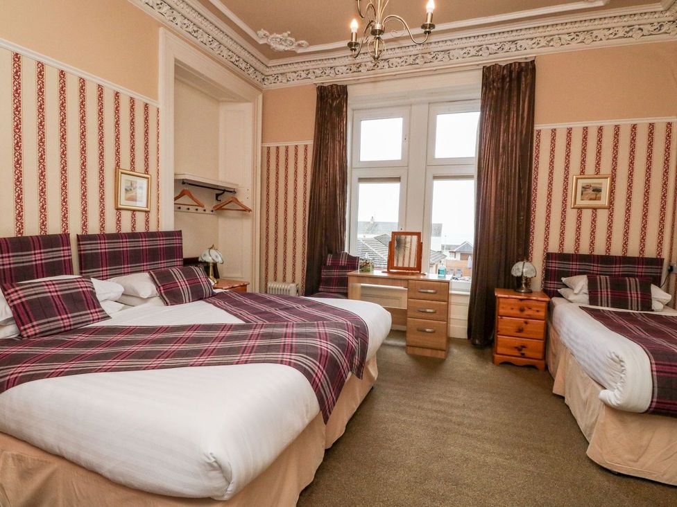 A bedroom with two beds and a dressing table at Seaview Wellness Retreat in Carnoustie