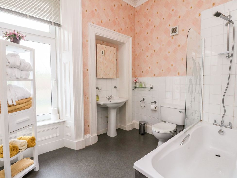 A bathroom with a sink, toilet, bathtub, and towels at Seaview Wellness Retreat in Carnoustie