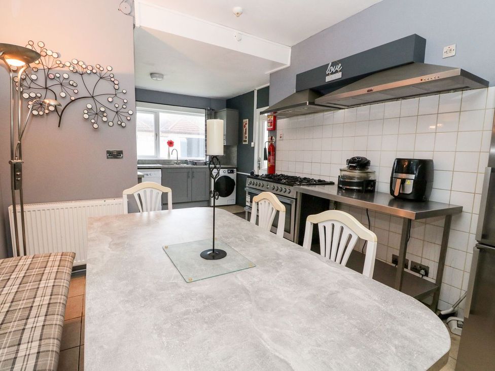 A kitchen with a dining table and appliances at Seaview Wellness Retreat in Carnoustie