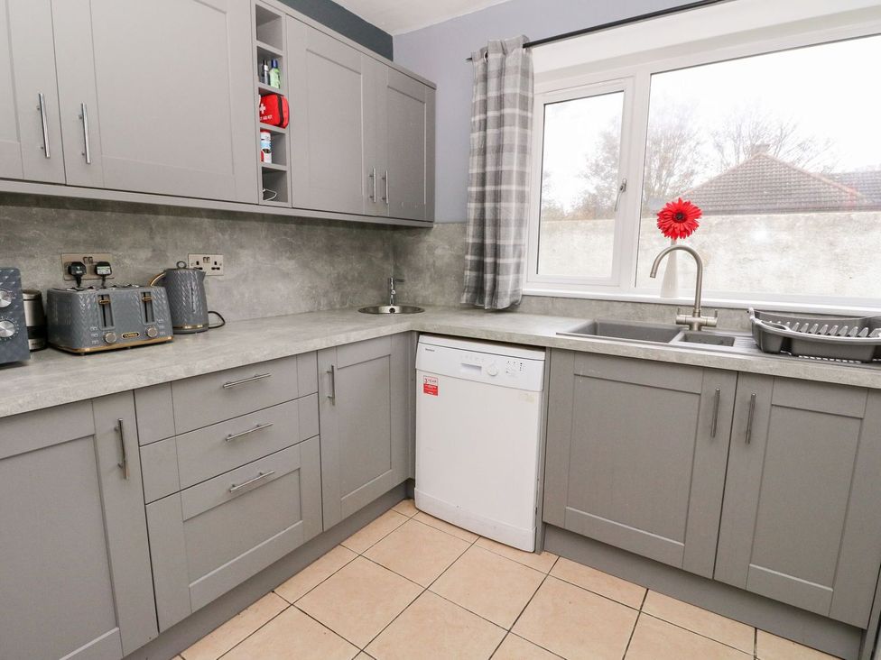 A kitchen with grey cabinets and a dishwasher at Seaview Wellness Retreat in Carnoustie