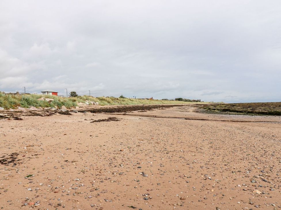 A beach with sand and grass at Seaview Wellness Retreat in Carnoustie