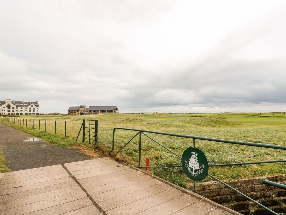 An outdoor view of a golf course and buildings at Seaview Wellness Retreat in Carnoustie