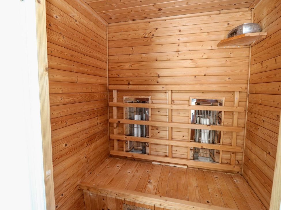 A sauna with wooden walls and heat lamps at Seaview Wellness Retreat in Carnoustie