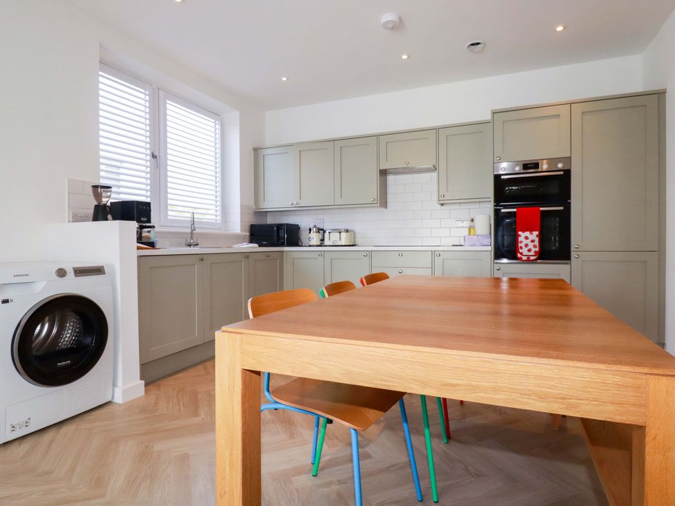 A kitchen with a table and chairs at Edens in Penwithick