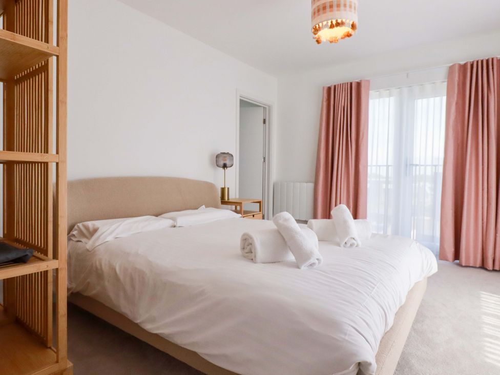 A bedroom with a bed and lamp at Edens in Penwithick