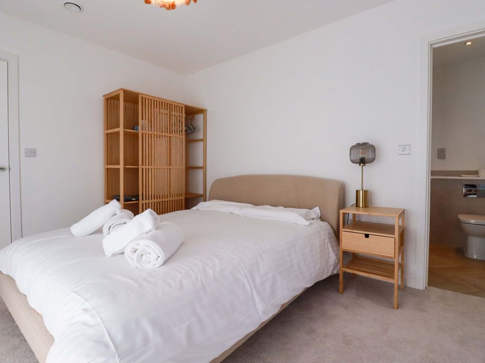 A bedroom with a bed and a bookshelf at Edens in Penwithick