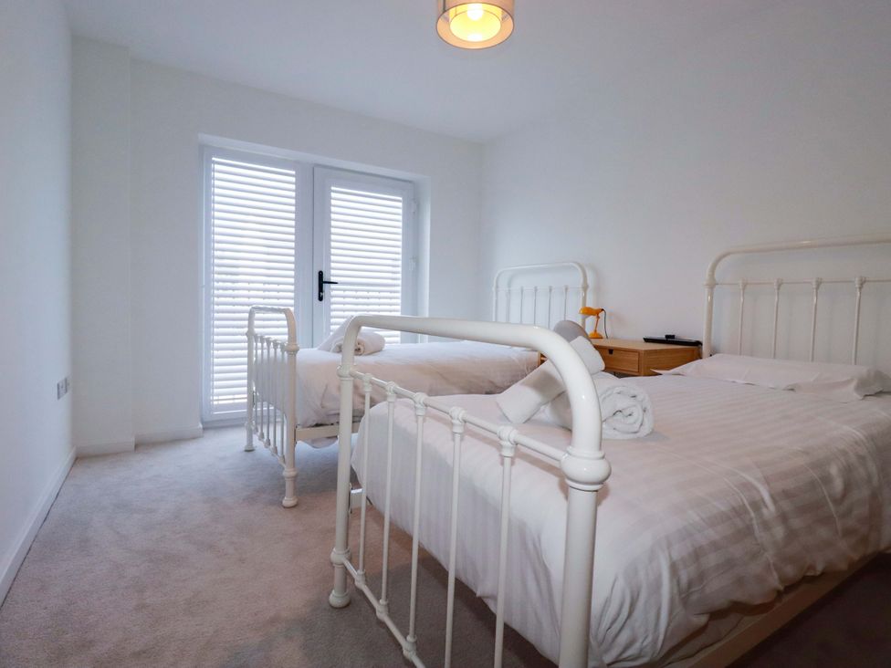 A bedroom with two beds and a dresser at Edens in Penwithick