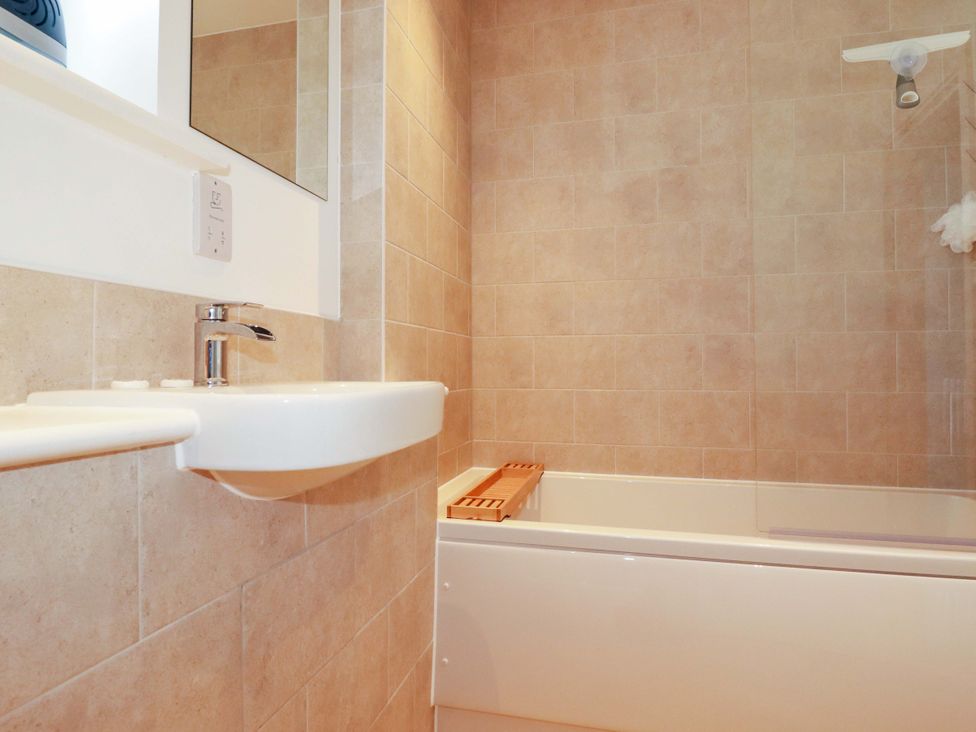 A bathroom with a sink and bath tub at Edens in Penwithick
