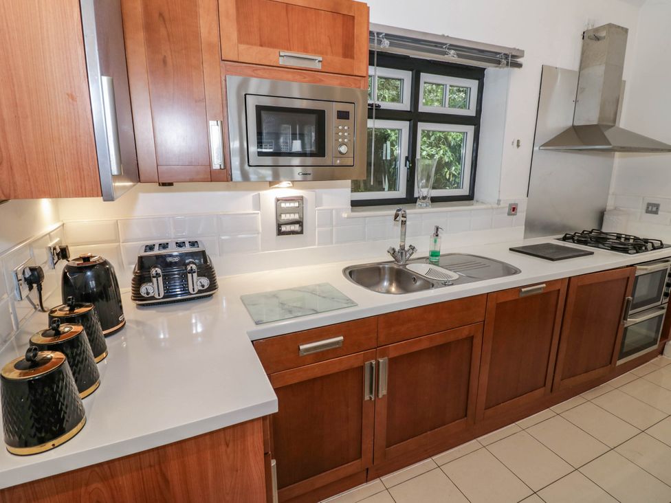 A kitchen with cabinets, sink, and appliances at Tudor Lodge in Birmingham