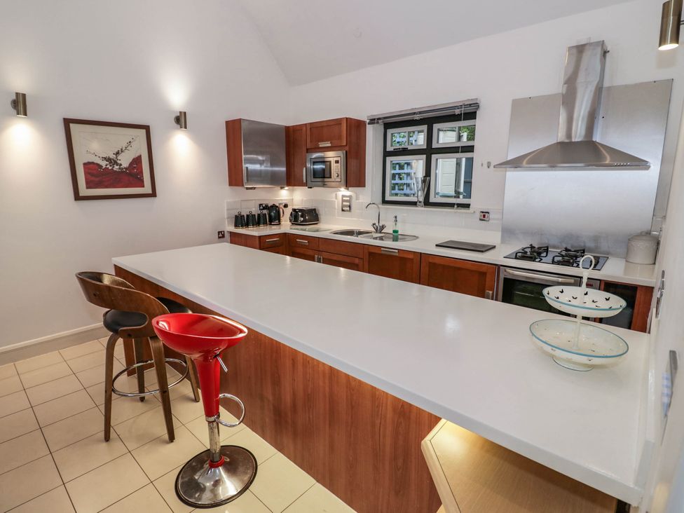 A kitchen with a kitchen island and stools at Tudor Lodge in Birmingham