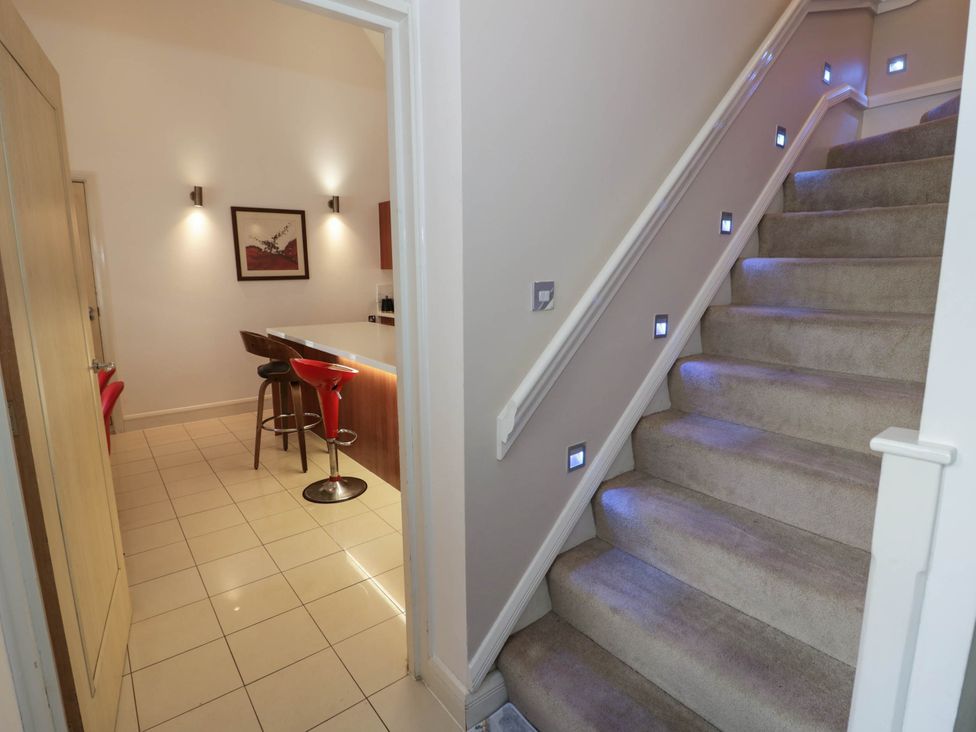 A hallway with a staircase and bar counter at Tudor Lodge in Birmingham