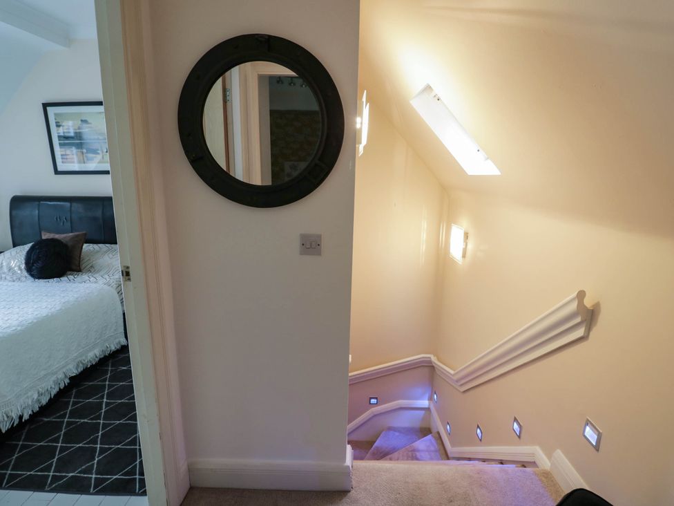 A hallway with a mirror and staircase at Tudor Lodge Birmingham