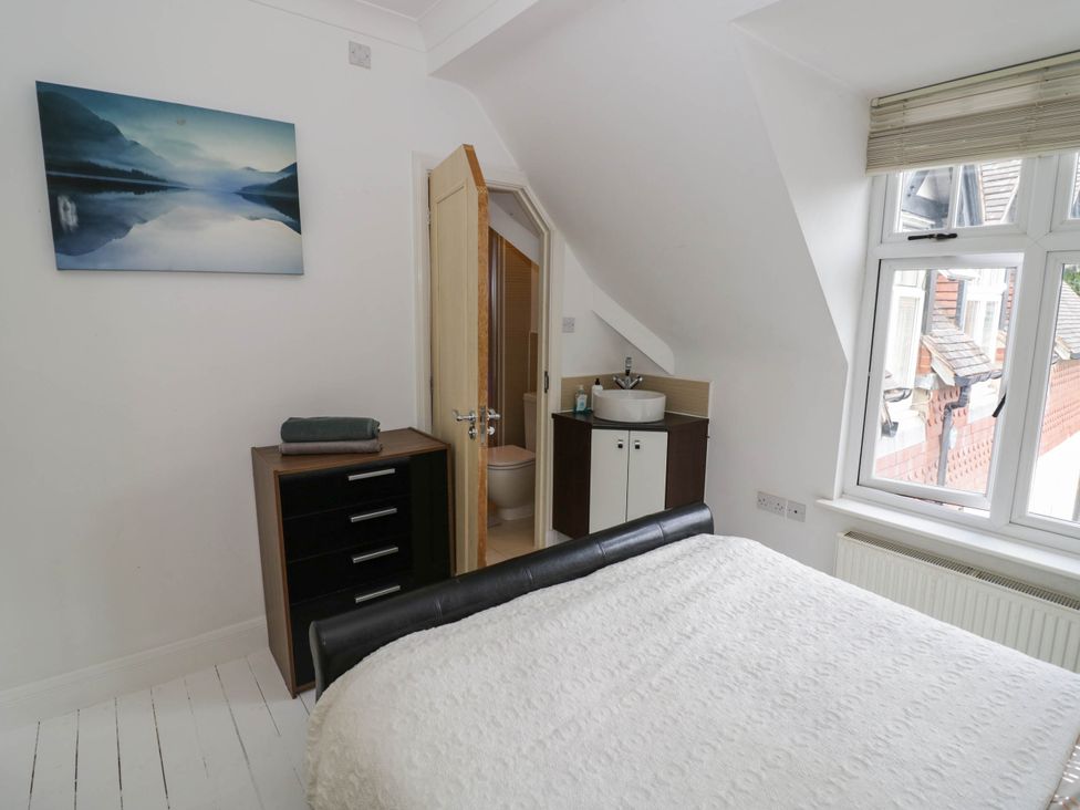 A bedroom with a bed and a door leading to a bathroom at Tudor Lodge in Birmingham