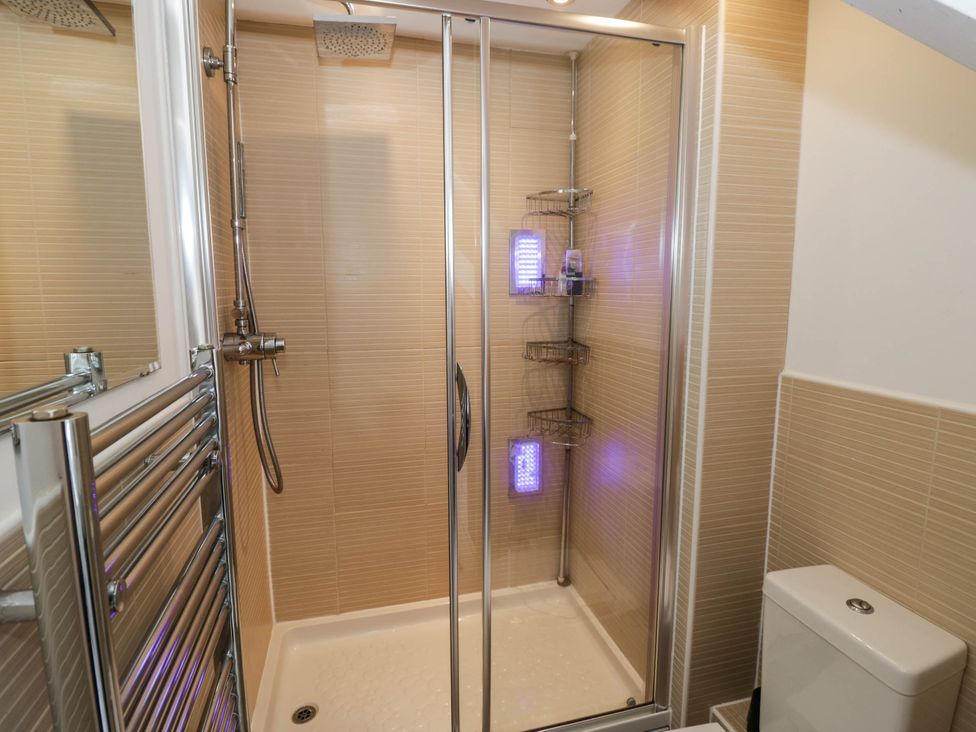 A shower stall with a towel radiator and toilet at Tudor Lodge in Birmingham