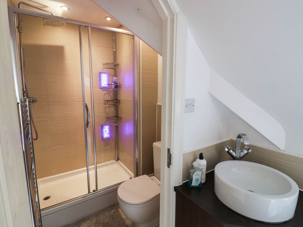 A bathroom with a shower, toilet, and wash basin at Tudor Lodge in Birmingham