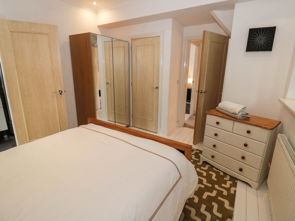 A bedroom with a bed and mirrored wardrobe at Tudor Lodge in Birmingham