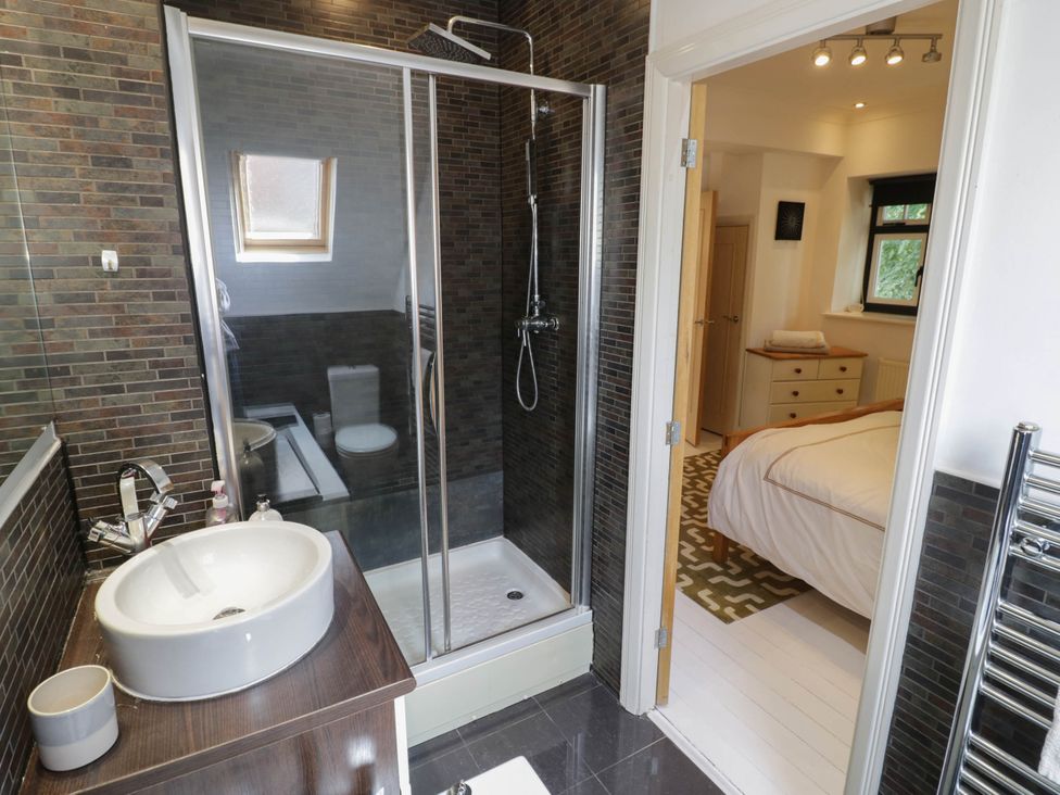 A bathroom with a shower, sink, and toilet at Tudor Lodge in Birmingham