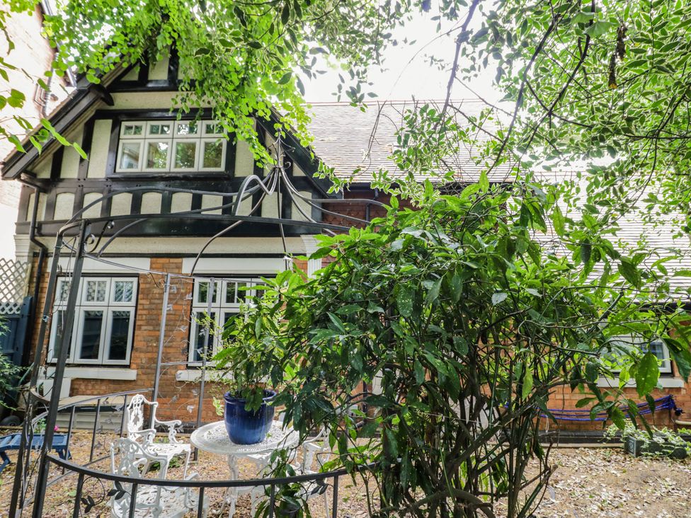 A house with a garden bench and table at Tudor Lodge in Birmingham