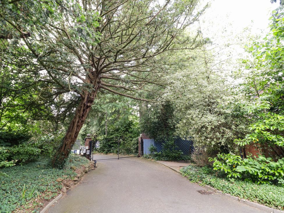 A pathway leading to a gate surrounded by trees at Tudor Lodge in Birmingham