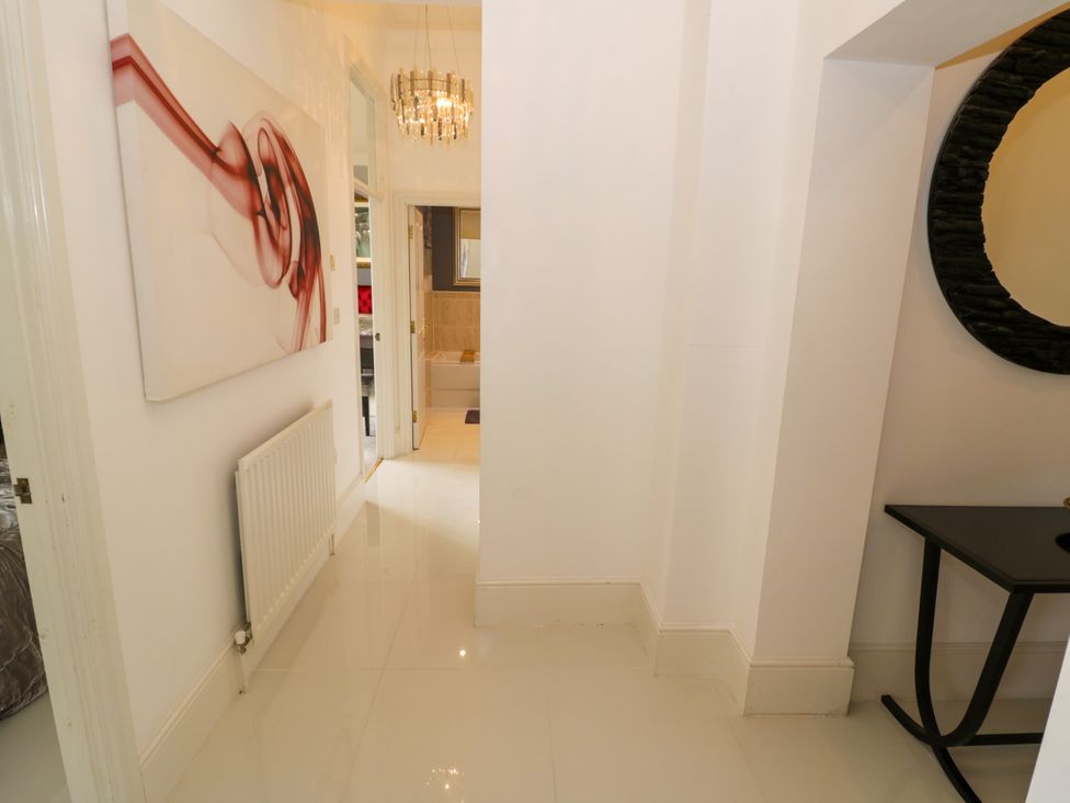 A hallway with a mirror and artwork at Manor House in Birmingham