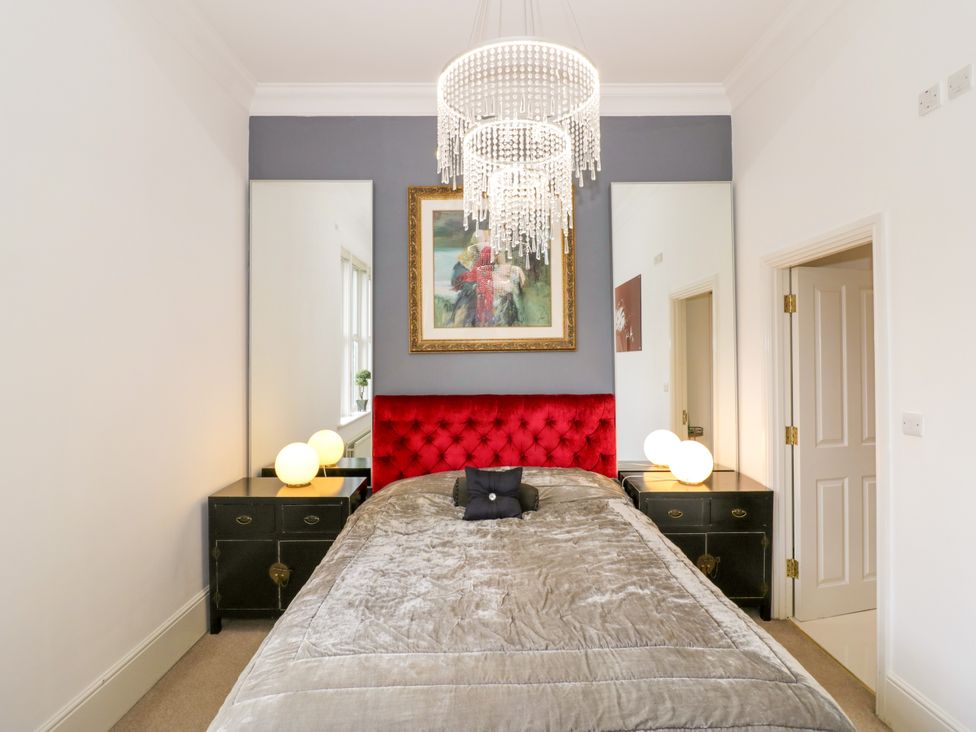 A bedroom with a red bed and nightstands at Manor House Birmingham