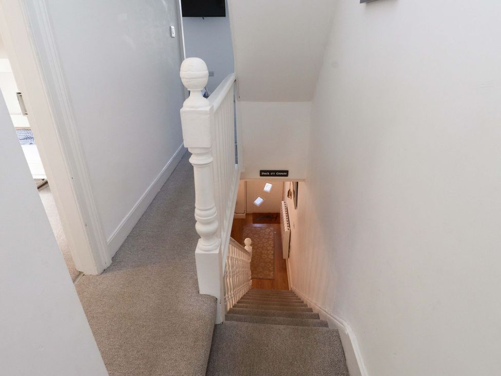 A staircase with a handrail and door at Bodefi in Pwllheli