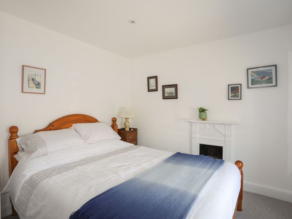 A bedroom with a bed and pictures on the wall at Bodefi in Pwllheli