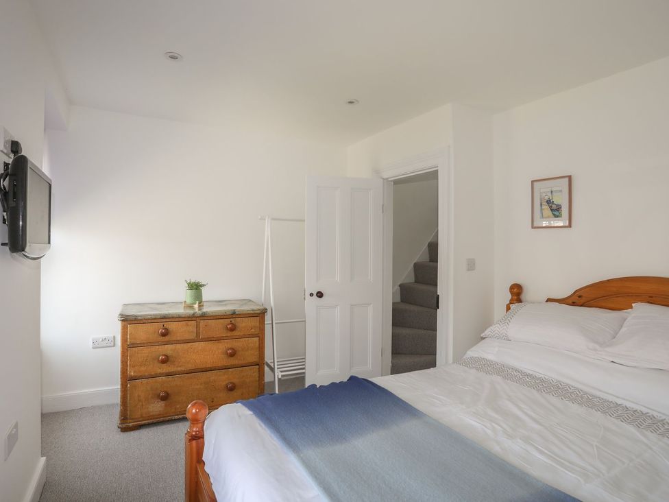 A bedroom with a bed and a dresser at Bodefi in Pwllheli