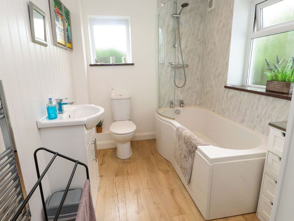 A bathroom with a bathtub, sink, and toilet at Bodefi in Pwllheli